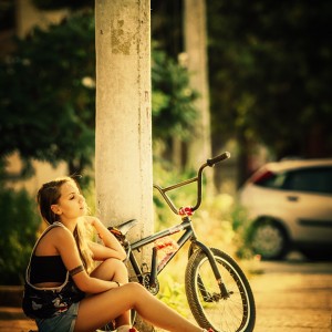 Young girl with bmx on the sunset street