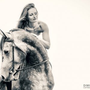Beautiful woman in white dress and black horse portrait