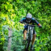 Mountainbiker rides jump in the forest