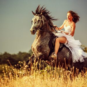 Woman riding wild horse
