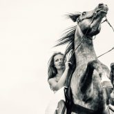 Young woman on rearing up beautiful horse
