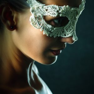 Portrait of young beautiful stylish woman in white lace mask